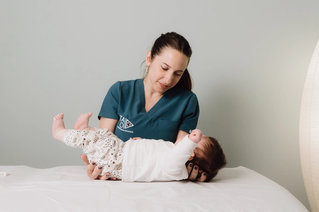 Fisioterapeuta en TAO Fisioterapia aplicando osteopatía pediátrica a un bebe